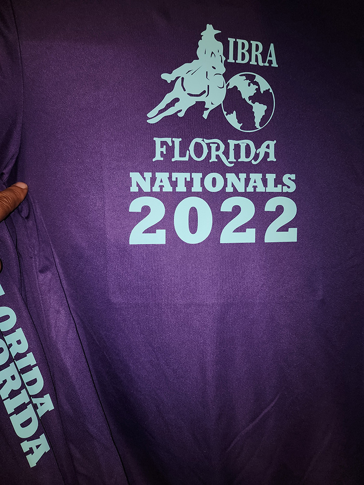 international barrel racing association team shirt lettered on back, sleeve and chest. the shirt is a purple long sleeved dri-fit shirt with teal lettering